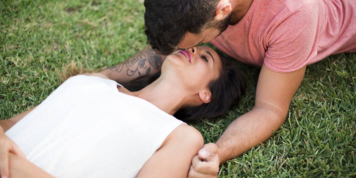Beautiful couple lying on the grass in the park - Couple Transgression